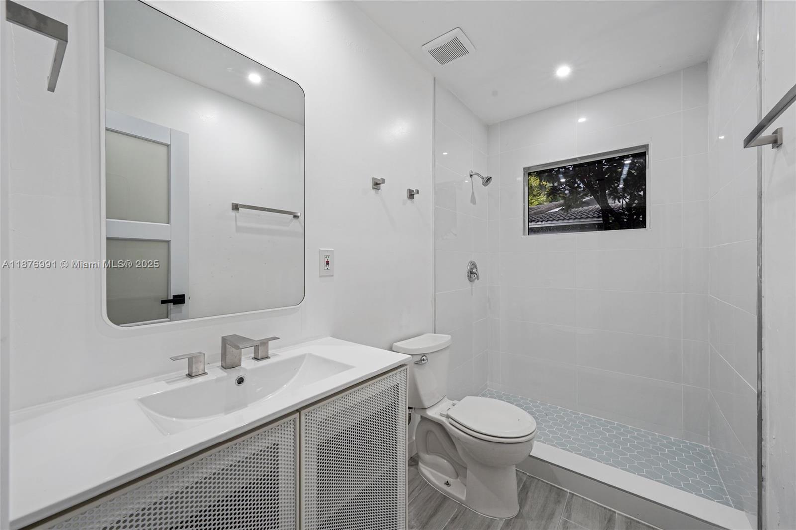 7516 Northwest 44th Court, Unit B Coral Springs, FL 33065 - Photo 19 of 26 a bathroom with a toilet a sink and mirror
