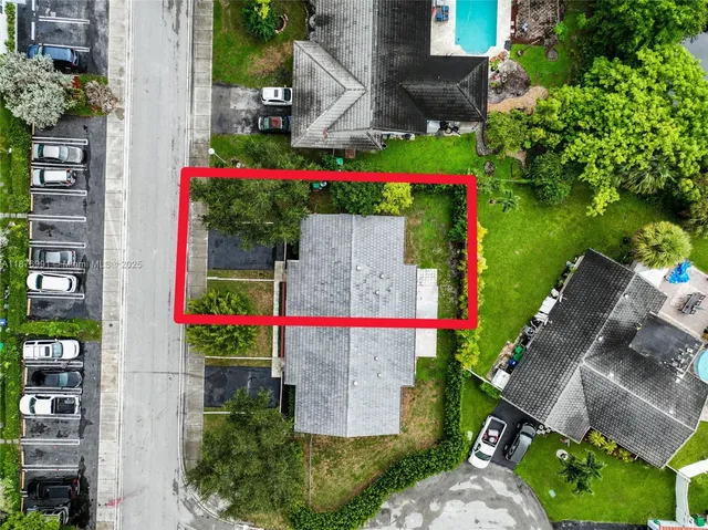 a aerial view of a house with sign board and yard