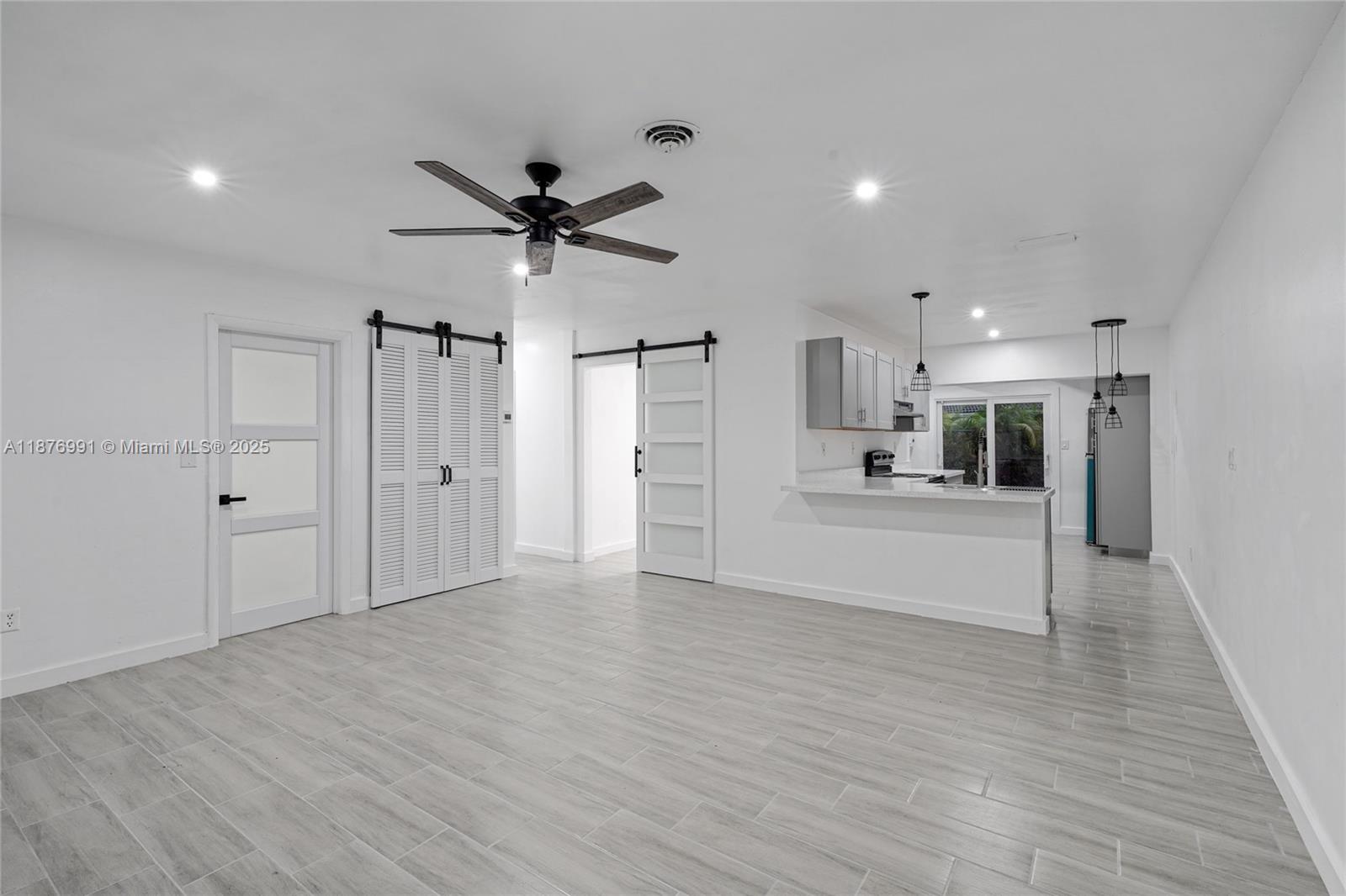 7516 Northwest 44th Court, Unit B Coral Springs, FL 33065 - Photo 5 of 26 a view of an empty room and kitchen view with wooden floor
