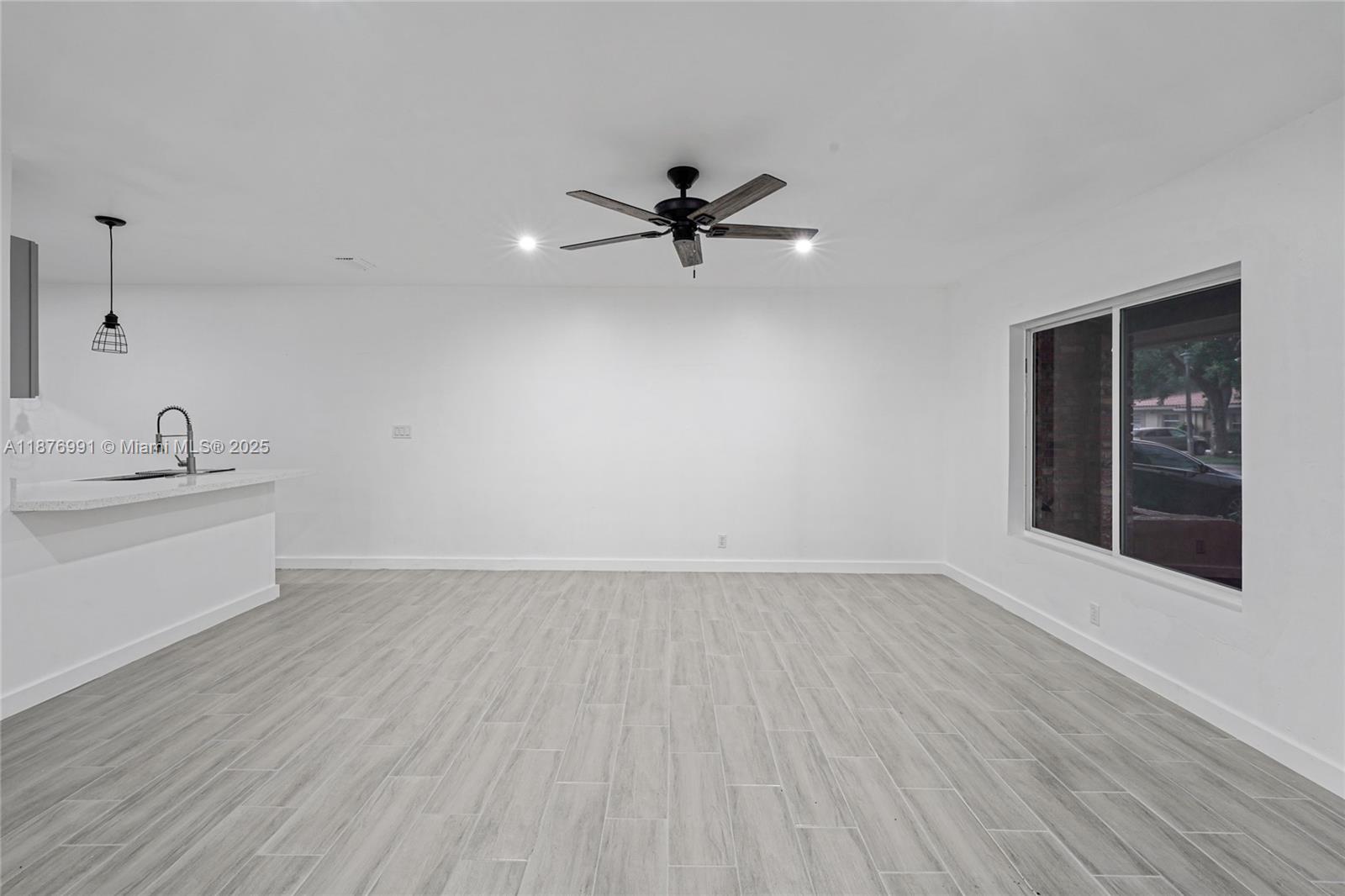 7516 Northwest 44th Court, Unit B Coral Springs, FL 33065 - Photo 6 of 26 wooden floor in an empty room with a window