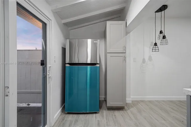 an empty room with wooden floor ceiling fan and windows