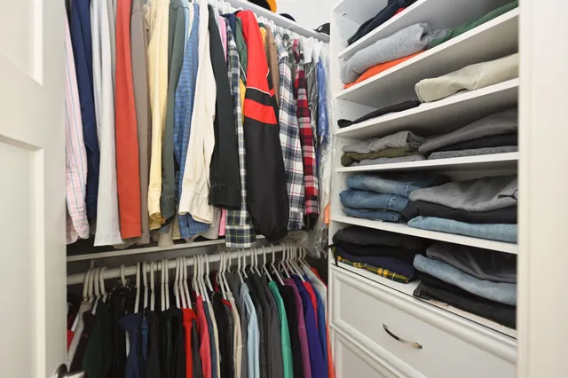 a view of walk in closet with clothes and shoes