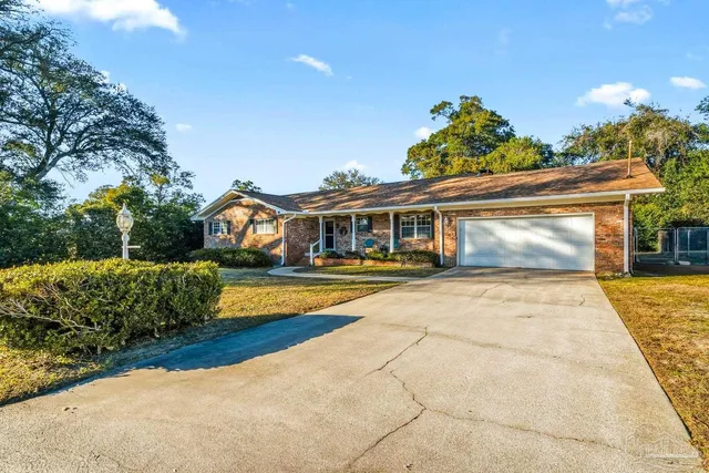 a front view of a house with a yard and potted plants