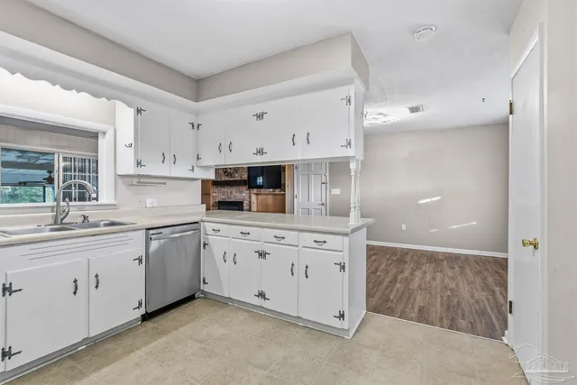 an empty room with chandelier fan and windows