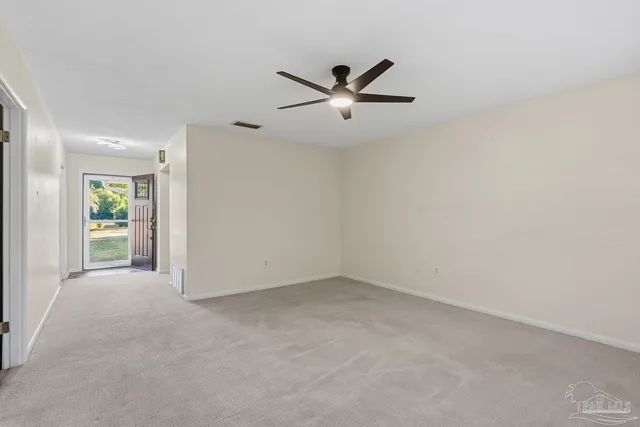 an empty room with a window and a fan