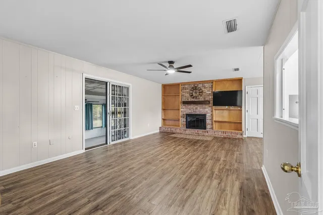 wooden floor fireplace and windows in an empty room