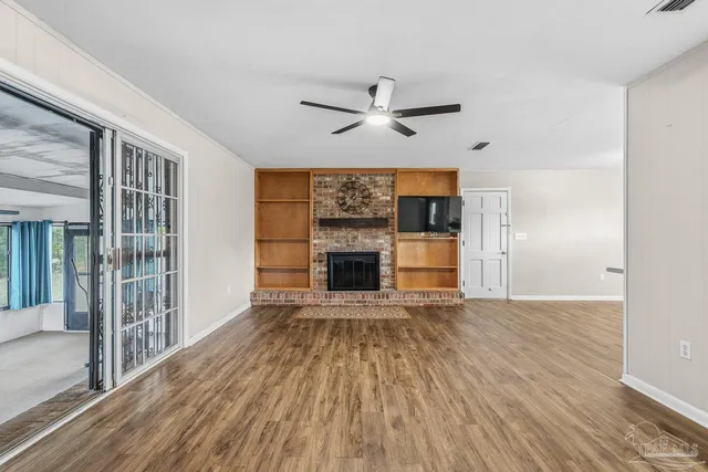 wooden floor fireplace and windows in an empty room