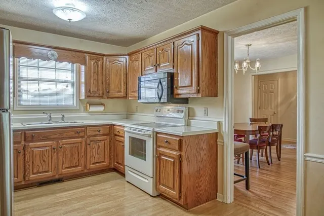 a kitchen with stainless steel appliances granite countertop a stove a sink and a microwave
