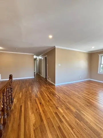 a view of empty room with wooden floor