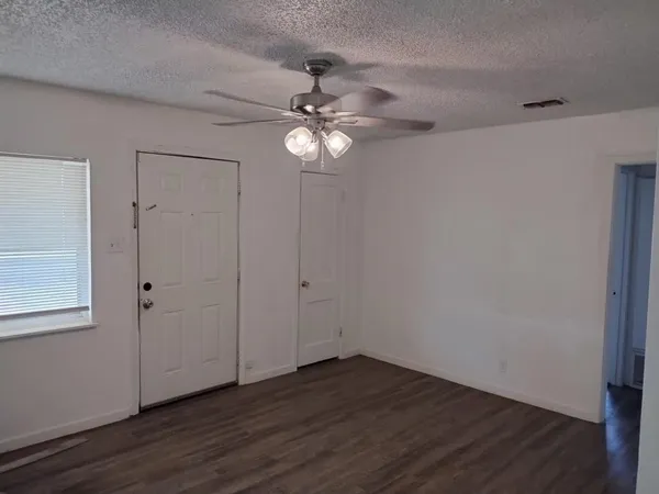 a view of an empty room with wooden floor