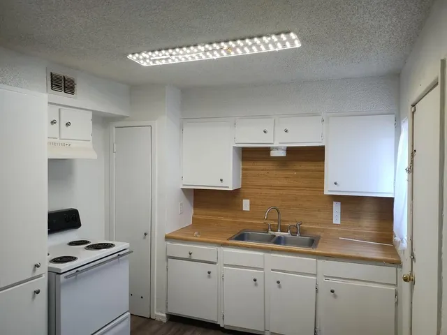a kitchen with stainless steel appliances white cabinets and a sink