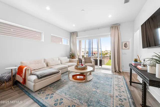 a living room with furniture flat screen tv and a window