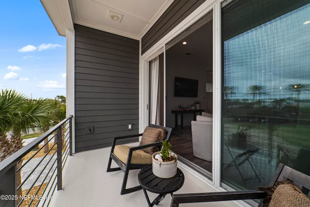 a balcony with chairs and a potted plant