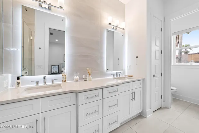 a bathroom with double sink and a mirror