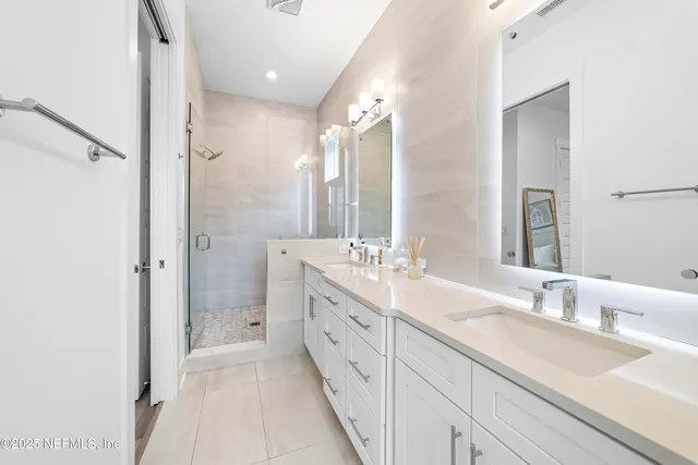 a spacious bathroom with a double vanity sink mirror double and shower