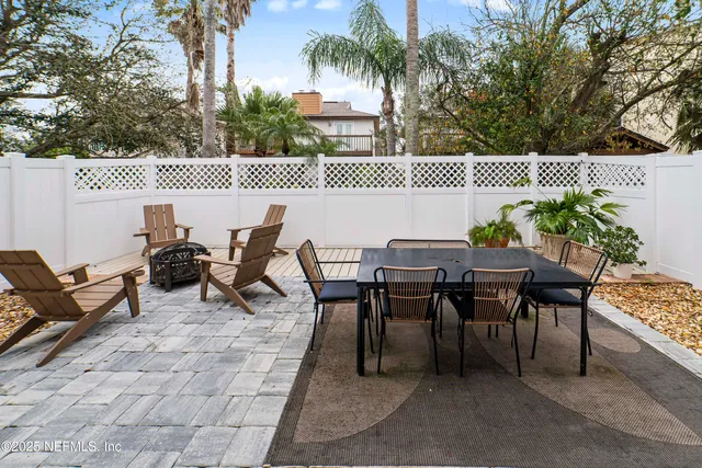 a roof deck with table and chairs and potted plants