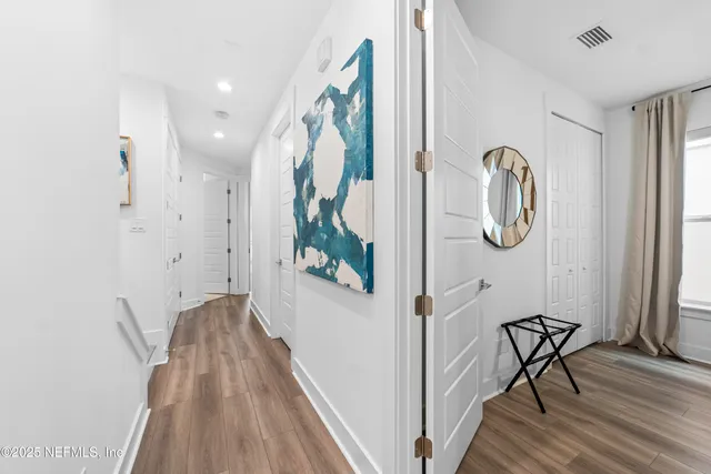 a view of a hallway with wooden floor and entryway
