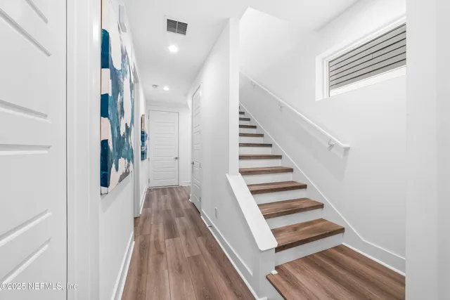 a view of a hallway with wooden floor and entryway
