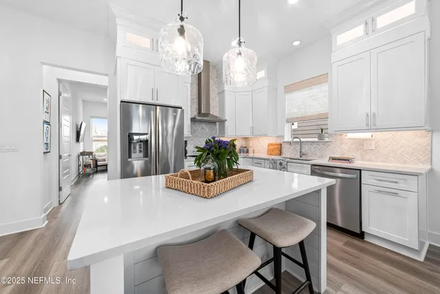 a kitchen with kitchen island a table and chairs in it