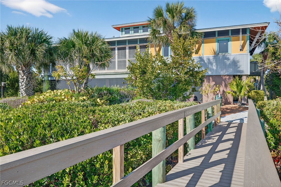 5703 Sanibel Captiva Road Sanibel, FL 33957 - Photo 1 of 50 a view of balcony with wooden floor and fence and a potted plant