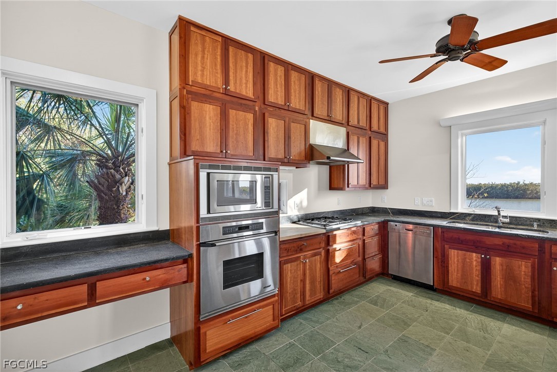5703 Sanibel Captiva Road Sanibel, FL 33957 - Photo 21 of 50 a kitchen with stainless steel appliances granite countertop a stove and a sink