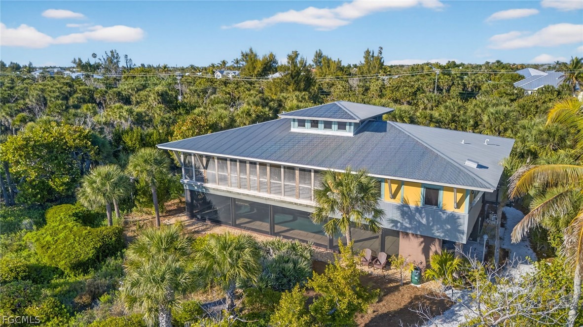 5703 Sanibel Captiva Road Sanibel, FL 33957 - Photo 45 of 50 a view of a big house with a big yard plants and large trees