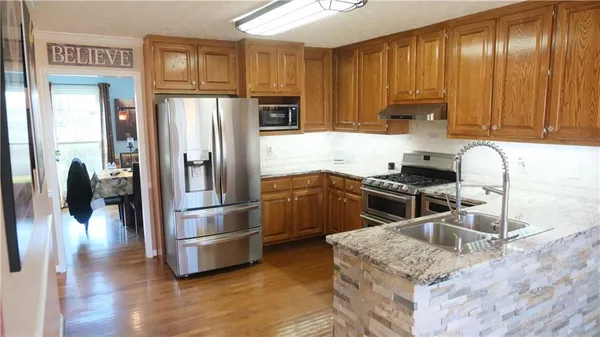 a kitchen with granite countertop stainless steel appliances and wooden cabinets