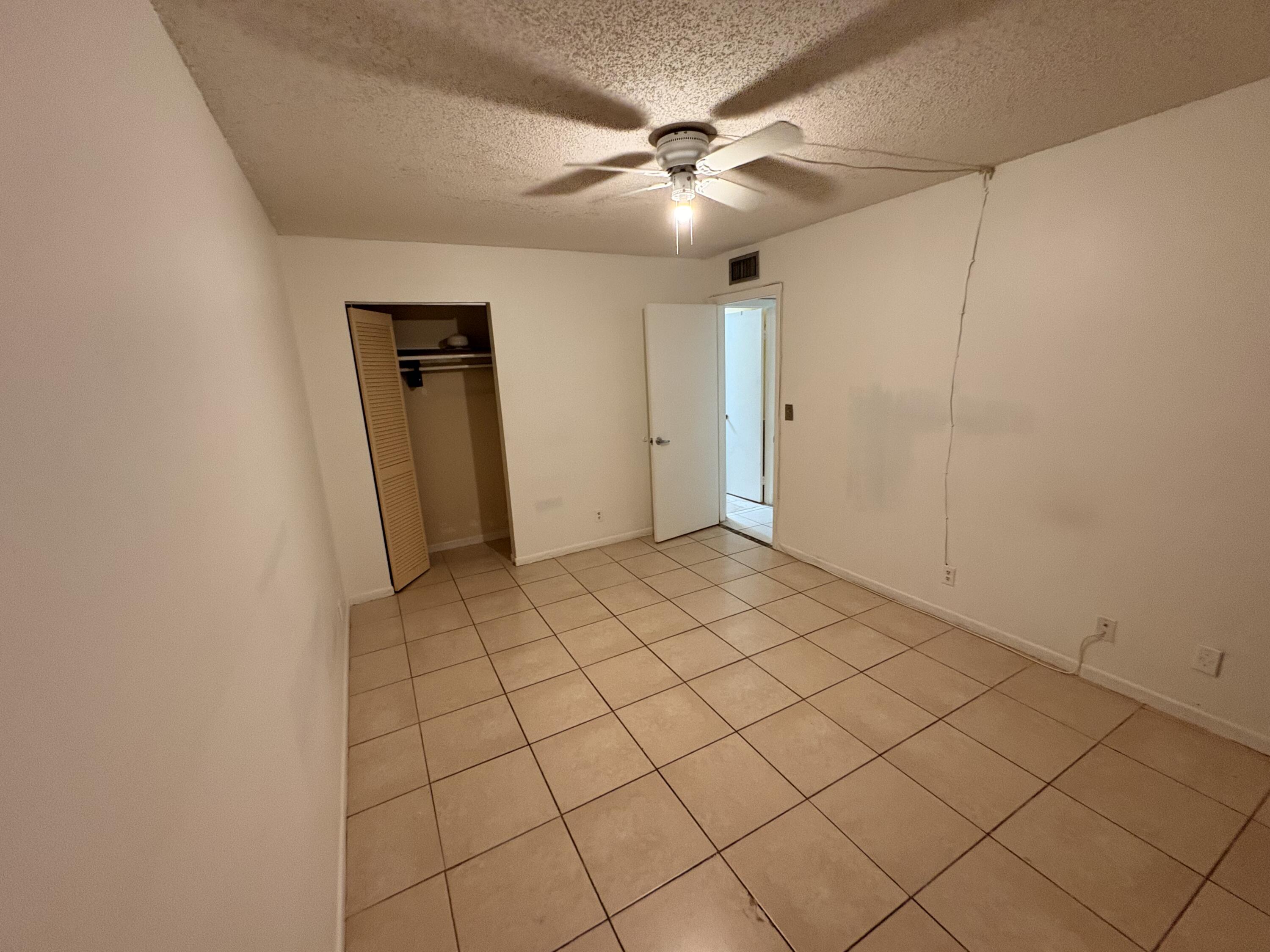 2925 Southwest 22nd Avenue, Unit 202 Delray Beach, FL 33445 - Photo 14 of 14 a view of a livingroom with an empty space and a ceiling fan