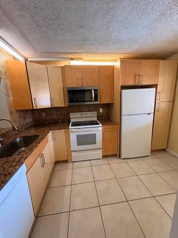 a kitchen with a stove a refrigerator and a sink