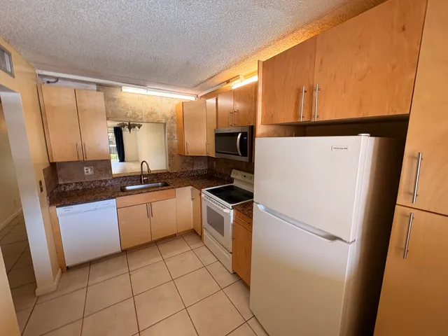 a kitchen with a sink a refrigerator and cabinets