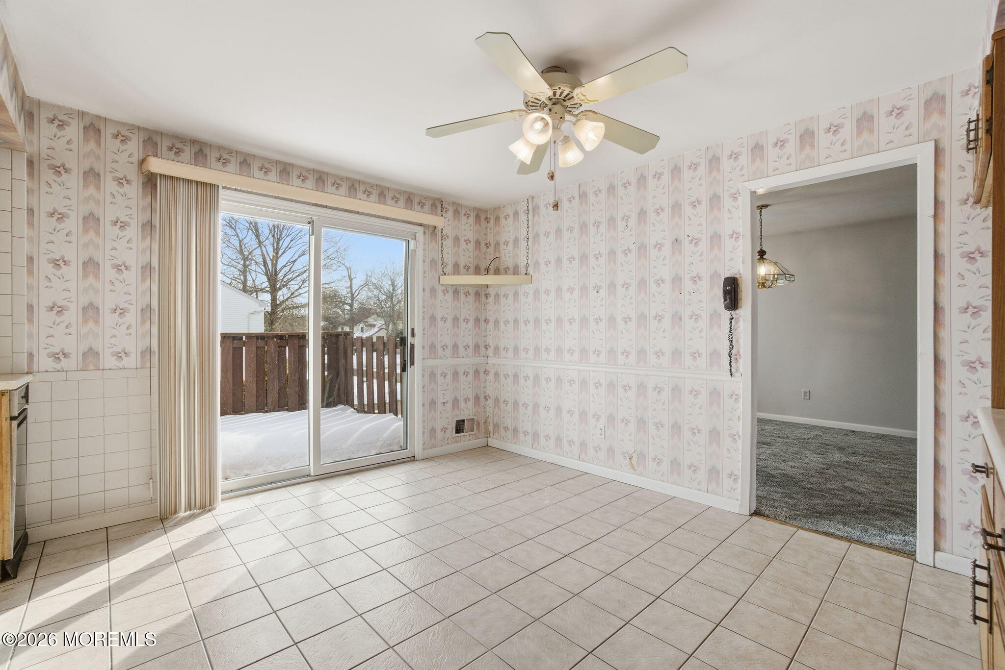 a view of entryway with an empty room and wooden floor