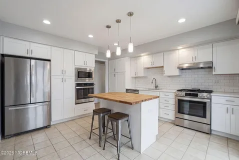 a kitchen with stainless steel appliances granite countertop a stove refrigerator sink and cabinets