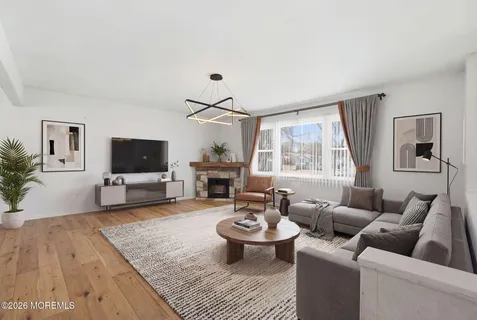 a living room with furniture a flat screen tv and a large window