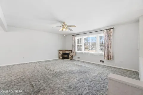 an empty room with fireplace and windows