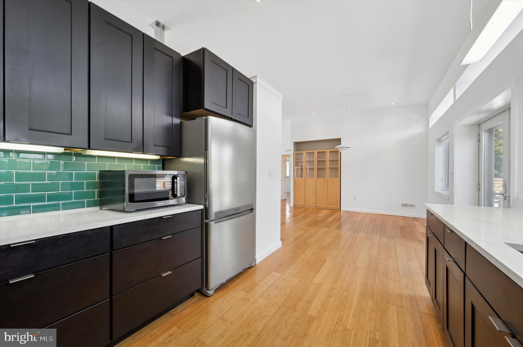 29 Rolling Road Wynnewood, PA 19096 - Photo 12 of 25 a kitchen with a sink a refrigerator and wooden cabinets