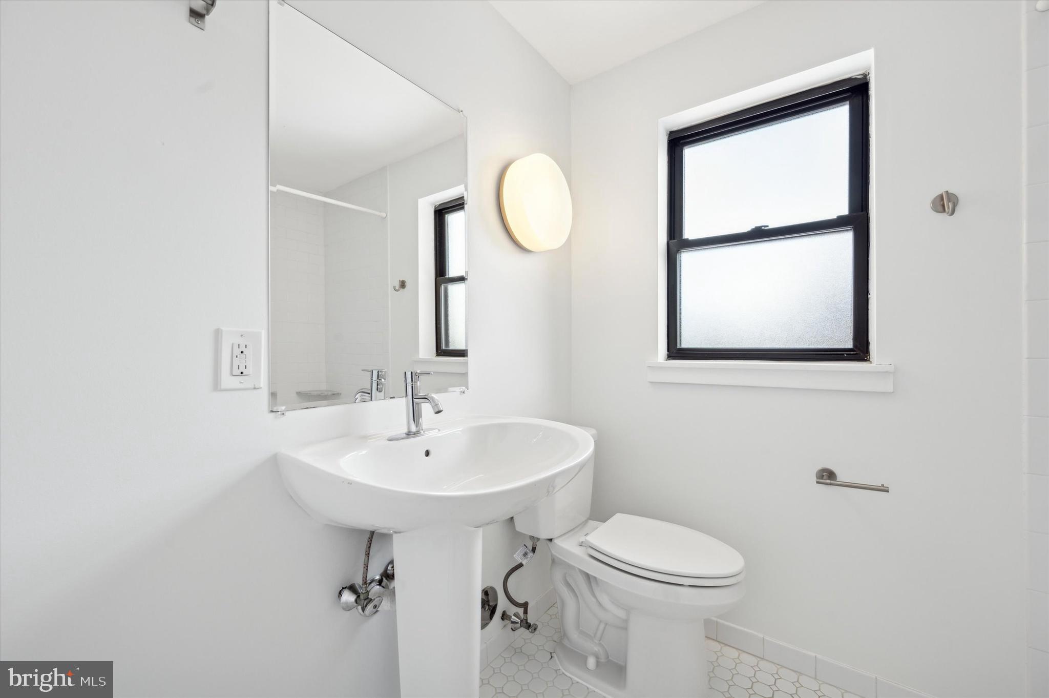 29 Rolling Road Wynnewood, PA 19096 - Photo 22 of 25 a bathroom with a sink a mirror and a toilet