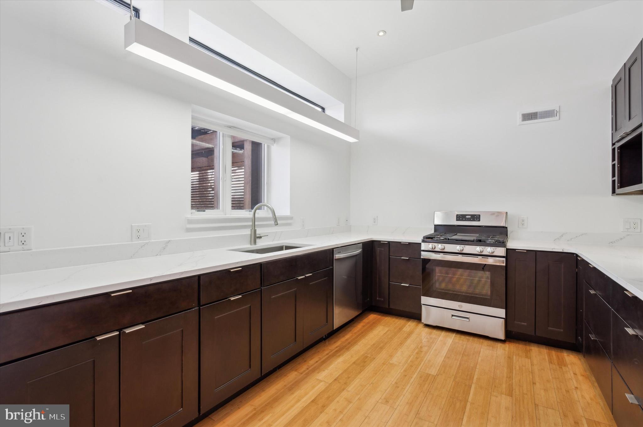 29 Rolling Road Wynnewood, PA 19096 - Photo 9 of 25 a kitchen with stainless steel appliances granite countertop a sink a stove a refrigerator and wooden cabinets
