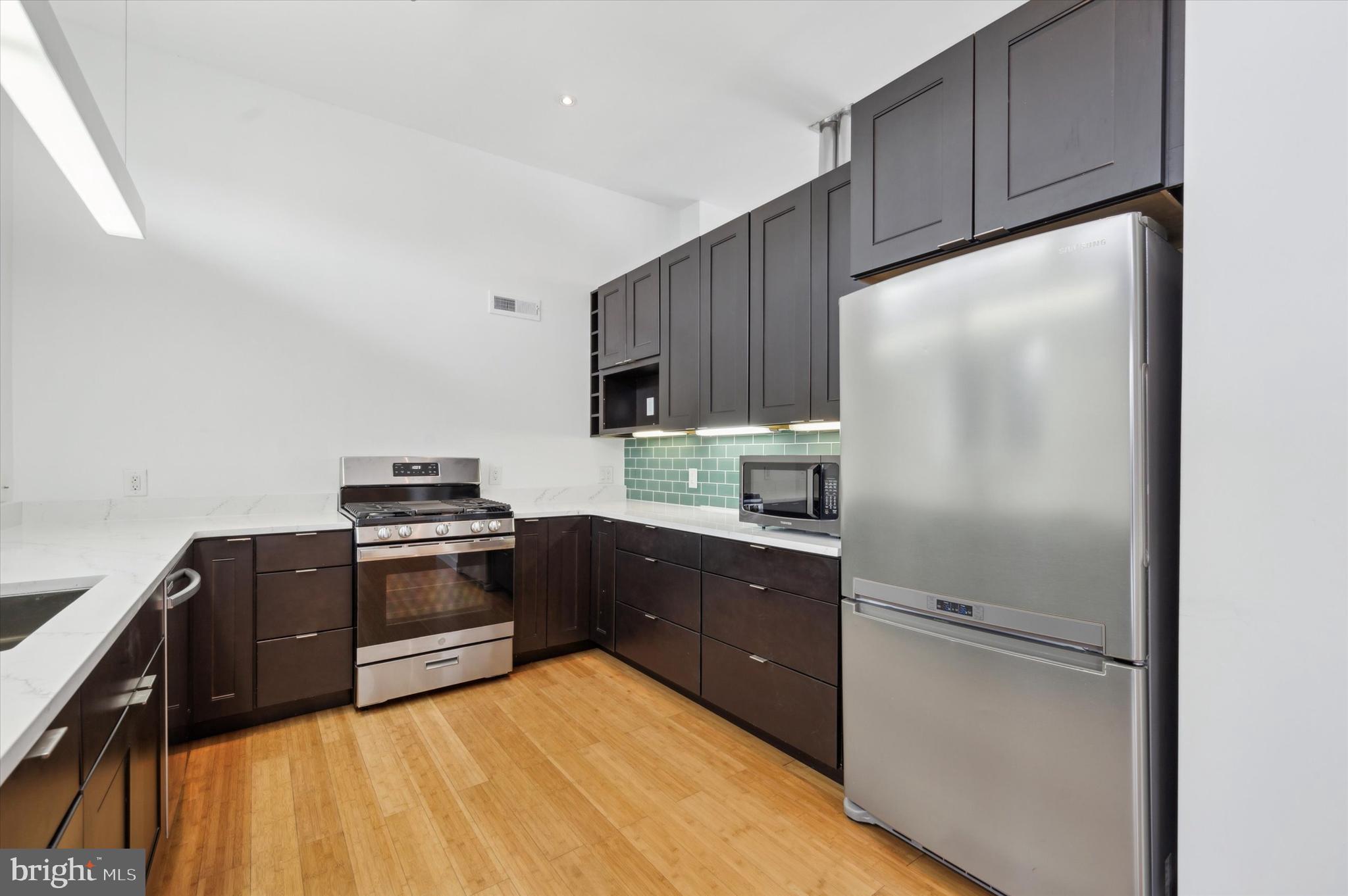 29 Rolling Road Wynnewood, PA 19096 - Photo 10 of 25 a kitchen with wooden cabinets and stainless steel appliances