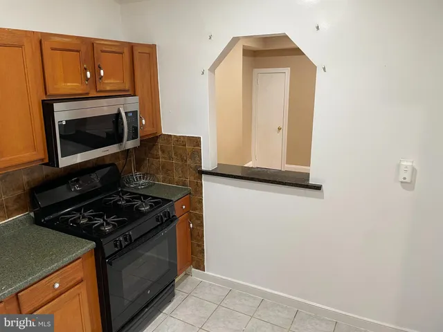 a kitchen with granite countertop cabinets and black appliances