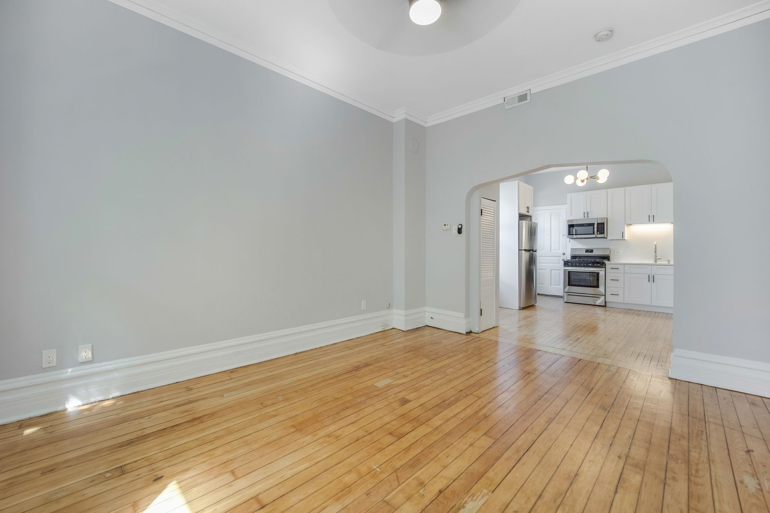 1346 West Webster Avenue, Unit 2F Chicago, IL 60614 - Photo 4 of 12 a view of a room with wooden floor and a kitchen