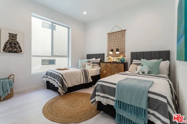 a bedroom with two beds and a window