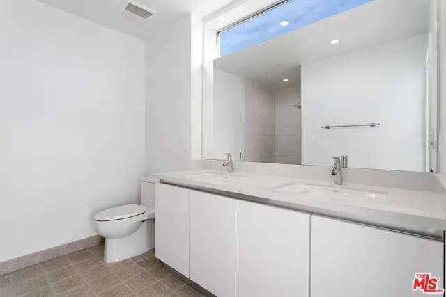a bathroom with a granite countertop sink a toilet and a mirror