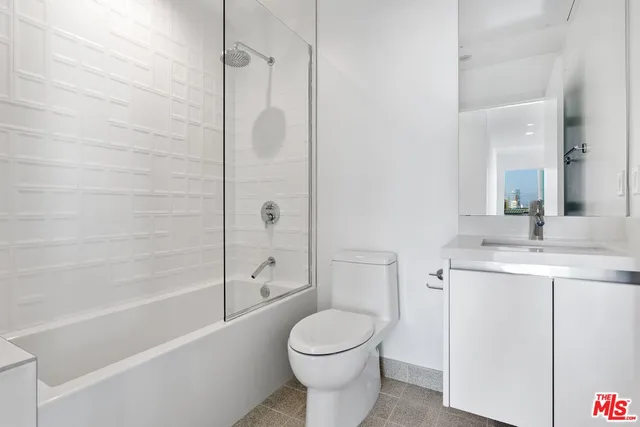 a bathroom with a toilet sink vanity and shower