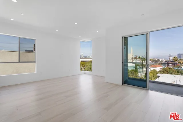 an empty room with large window and wooden floor