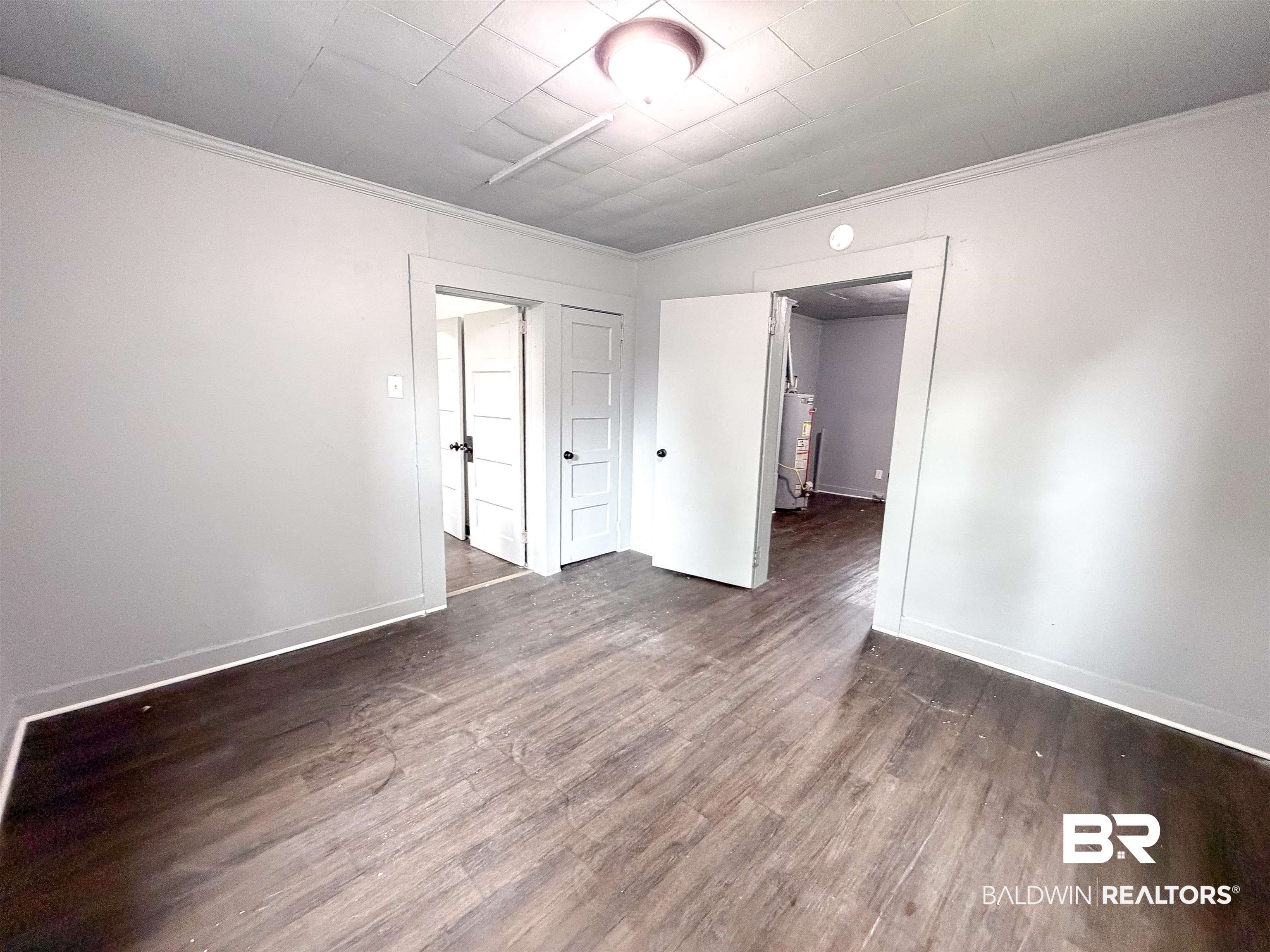 38 Flock Avenue Mobile, AL 36610 - Photo 14 of 27 Interior space featuring wood-finish flooring, light gray walls, white trim, and a flush mount ceiling light fixture