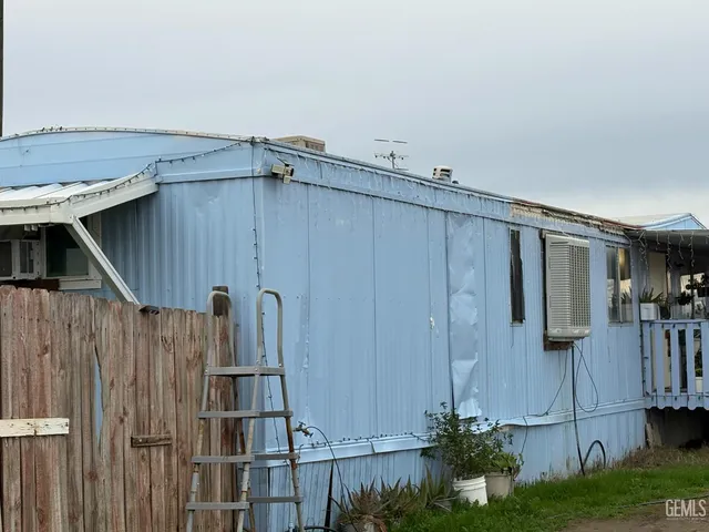 a view of a house with backyard and wooden fence