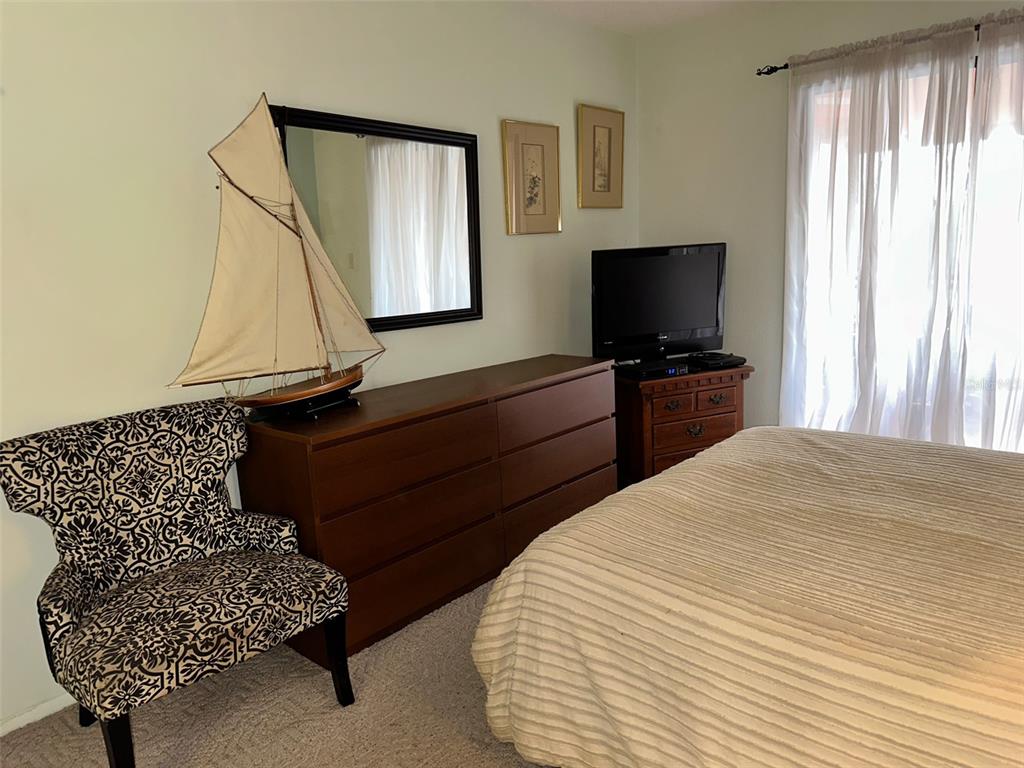 2829 74th Street West, Unit 2829 Bradenton, FL 34209 - Photo 12 of 27 a bedroom with a bed and a flat screen tv