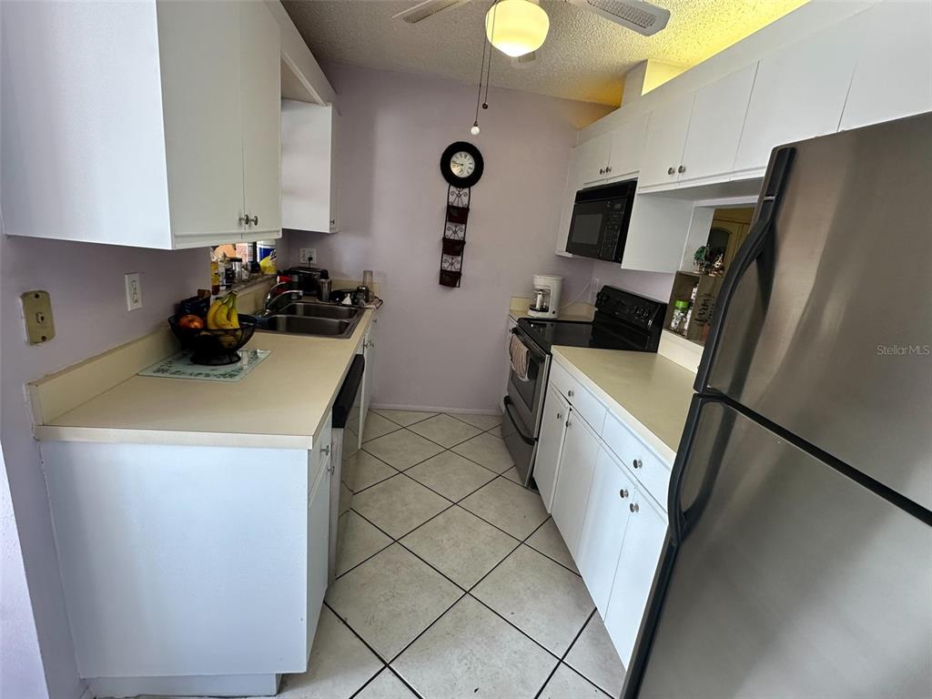 2829 74th Street West, Unit 2829 Bradenton, FL 34209 - Photo 6 of 27 a view of a kitchen with fridge and workspace