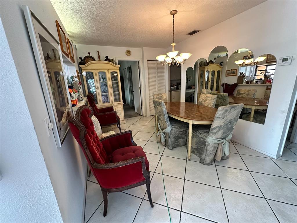 2829 74th Street West, Unit 2829 Bradenton, FL 34209 - Photo 9 of 27 a view of a dining room with furniture and chandelier