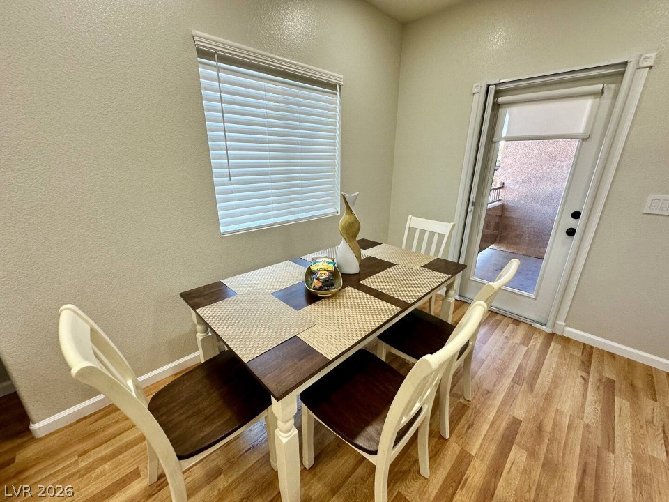 9580 West Reno Avenue, Unit 169 Las Vegas, NV 89148 - Photo 3 of 15 A cozy dining area features rich wood flooring and direct access to an outdoor space.